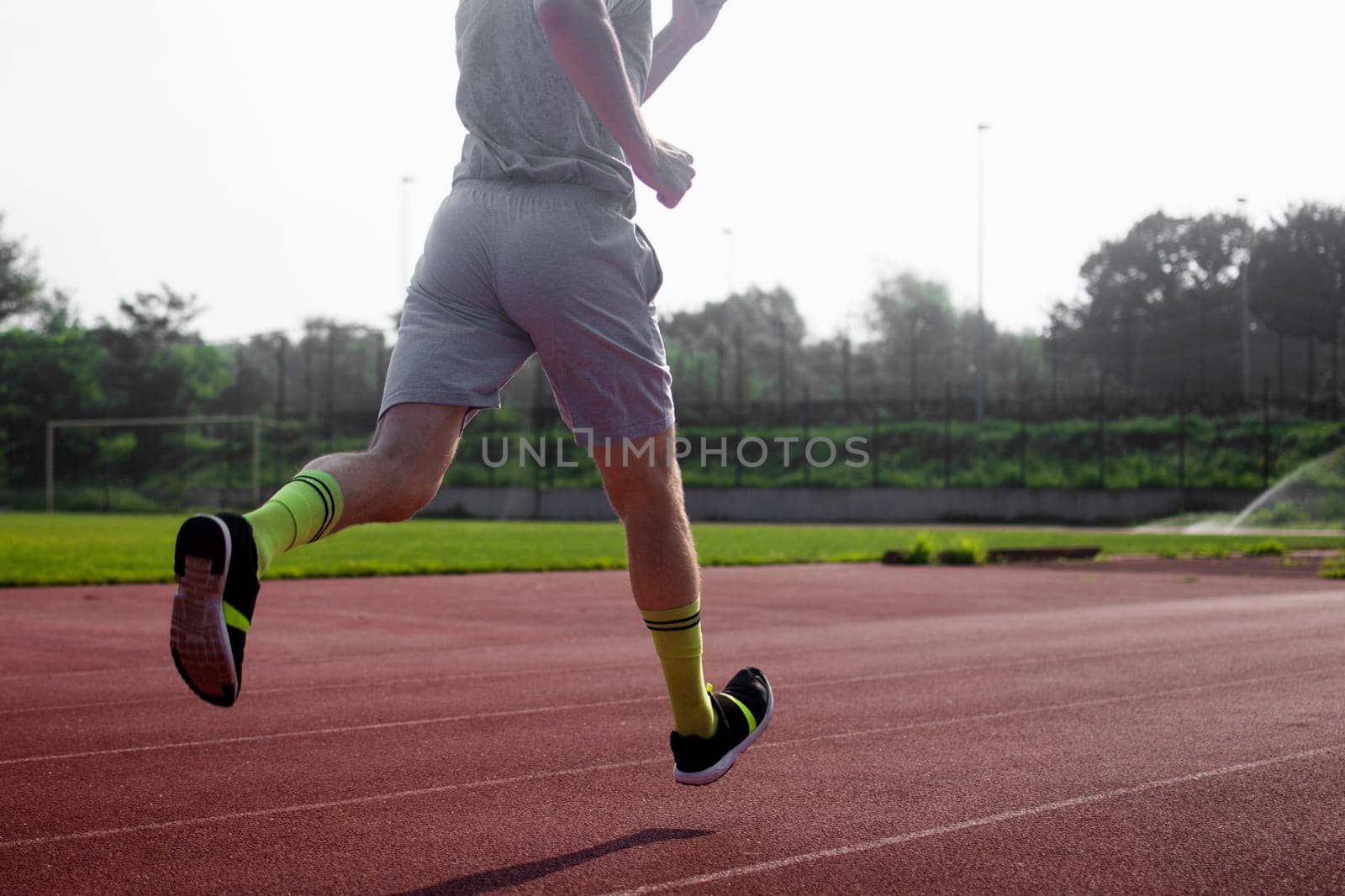 The runner is running at the stadium.
