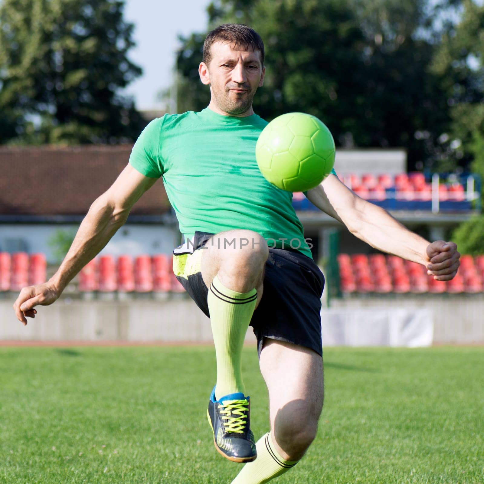 The football player is playing with the ball.