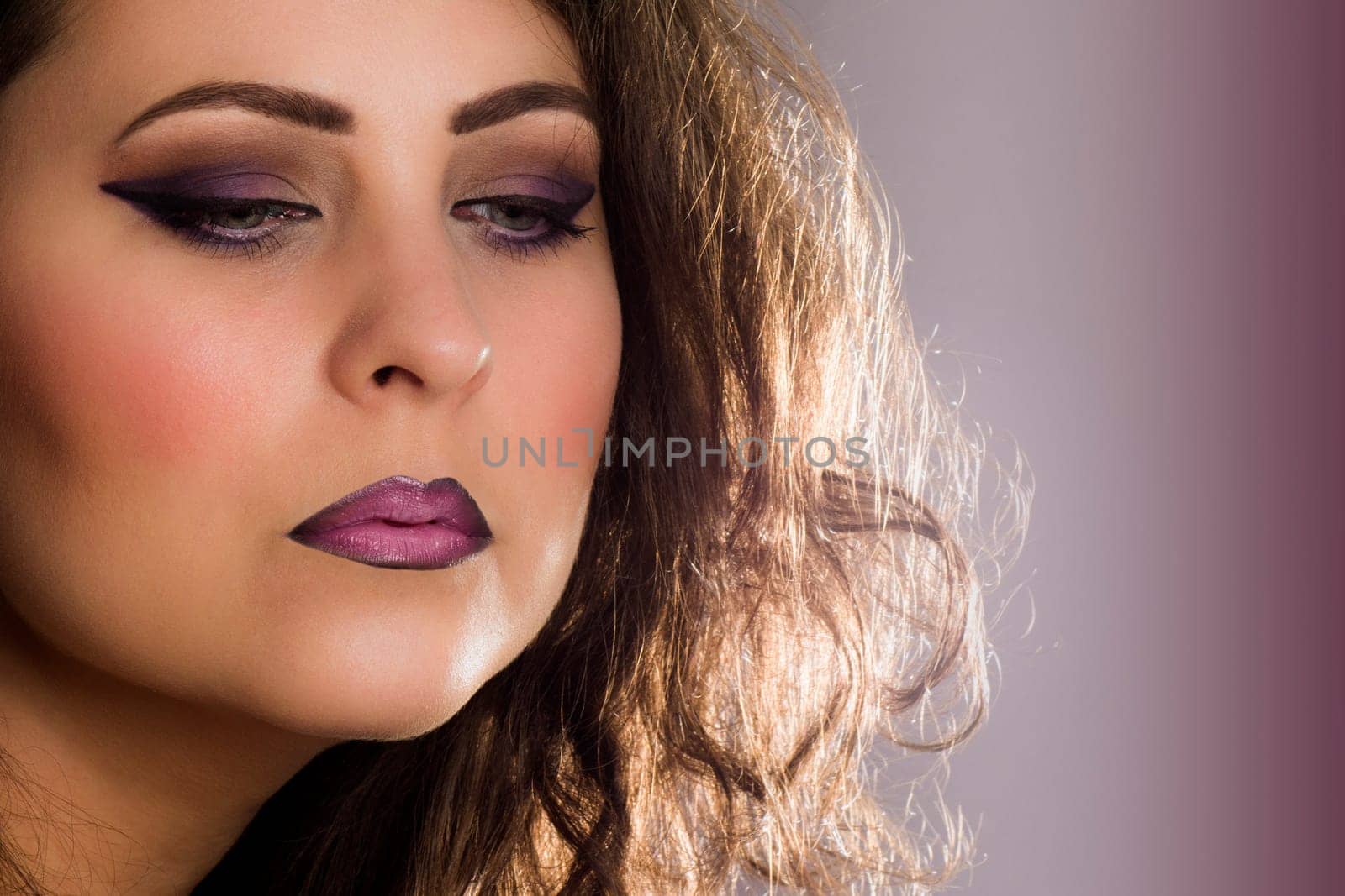 Retro beauty portrait with purple make-up on purple background.