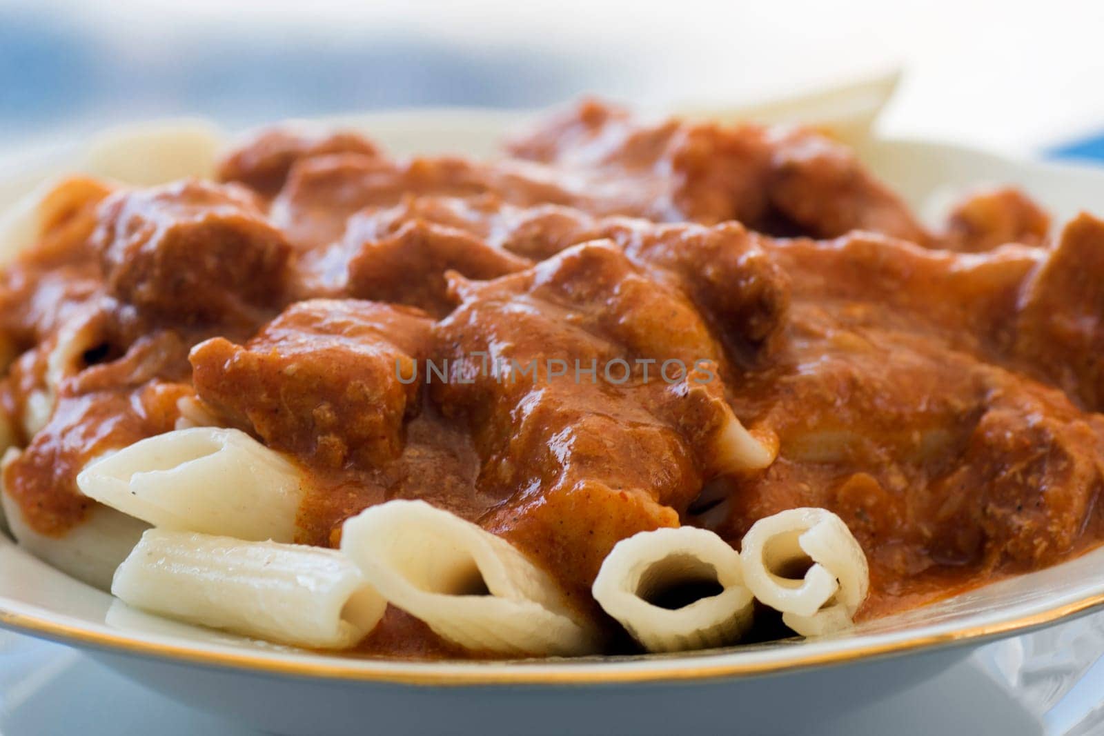 Beef stew, goulash with pasta is in plate.