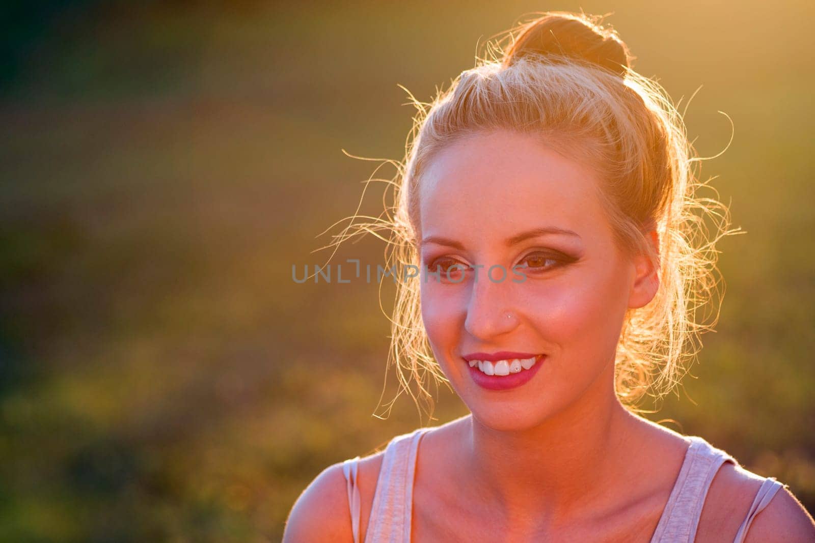 Portrait about a smiling cute young woman in nature.