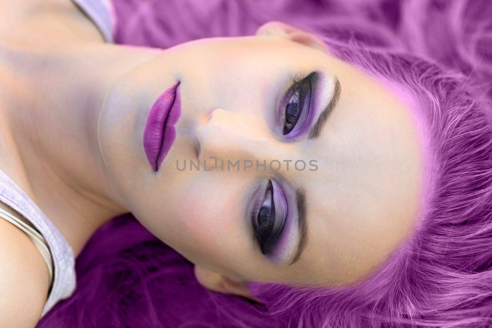 Beauty portrait of woman with purple hair and make-up.