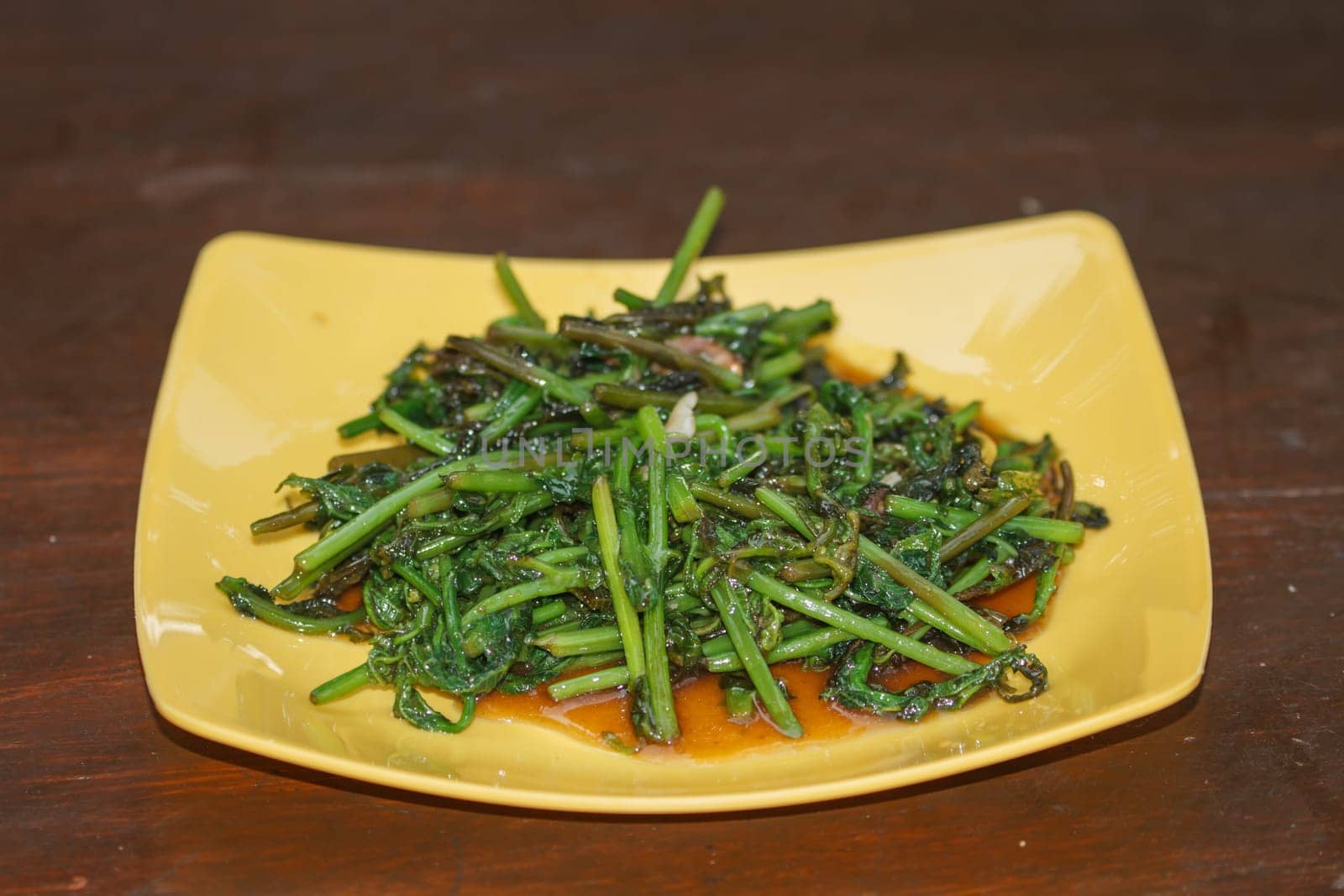 Fried vegetable fern in oyster sauce on table