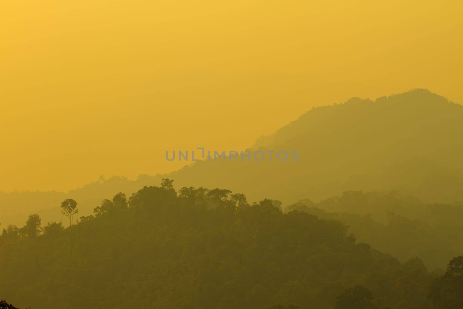 Sun shining through the clouds with silhouetted mountians