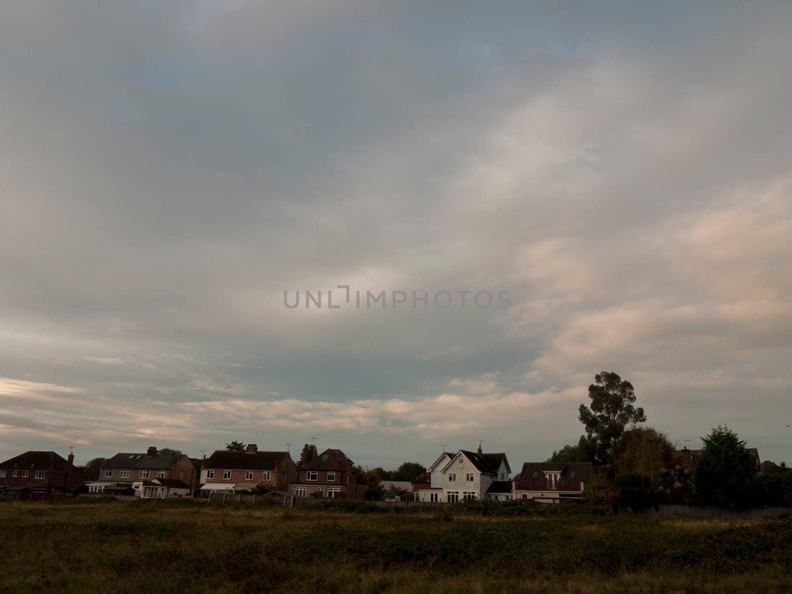 row of houses in country horizon with dramatic grey sky over head  essex  england  uk