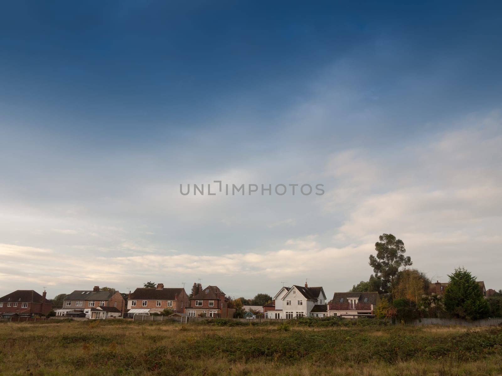 row of country houses with blue sky above horizon  essex  england  uk