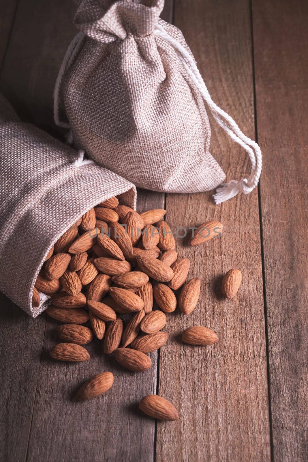A lot of almonds falling from inside the fabric bag.