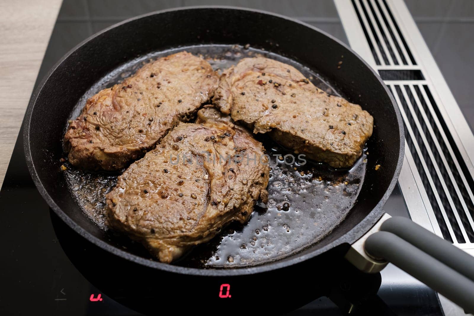 Beef marinated in cast iron frying pan on induction cooker