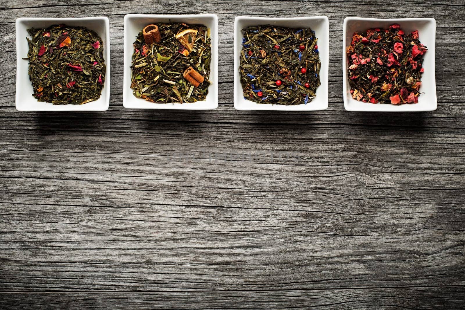 Dry tea collection of different types on wooden background
