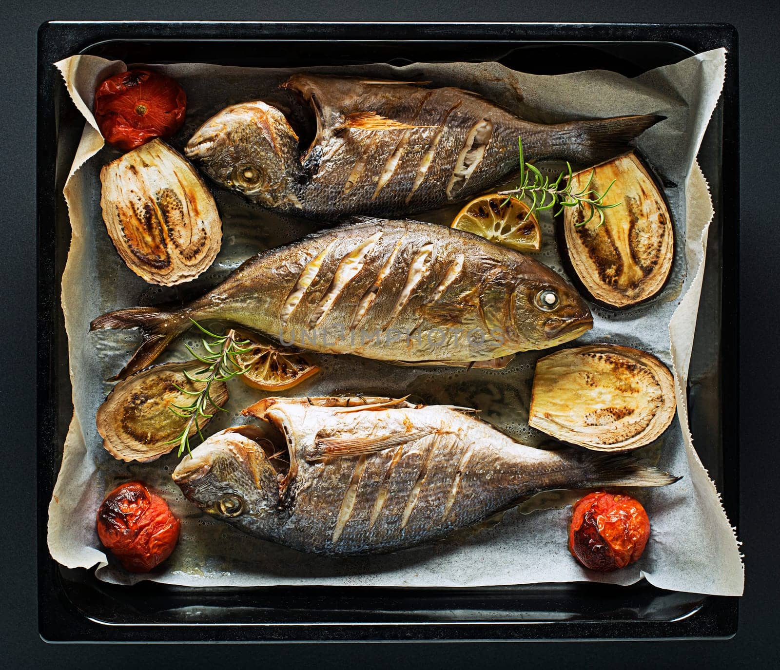 Grilled Gilt-head bream fish with lemon, herbs, oil, vegetables and spices