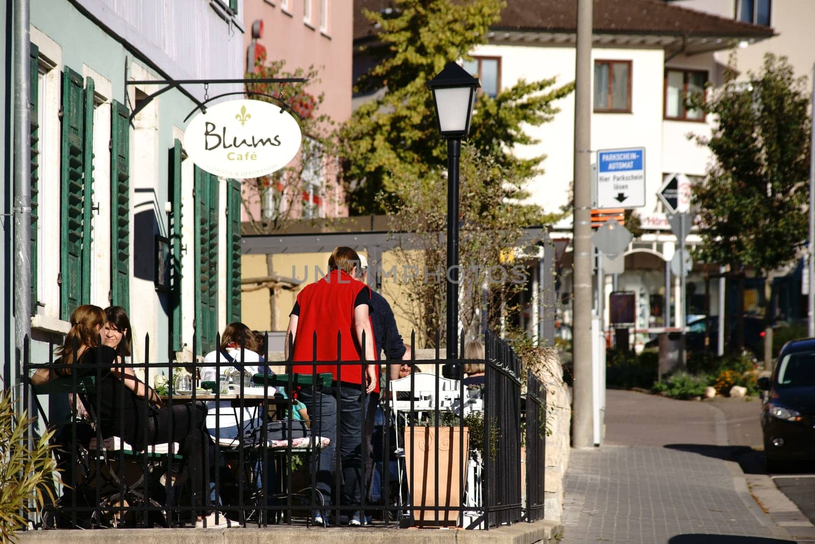 Nieder-Olm,Germany - October 14,2017: Visitors to Café Blums sit in the sunshine outside on a veranda on October 14,2017 in Nieder-Olm.