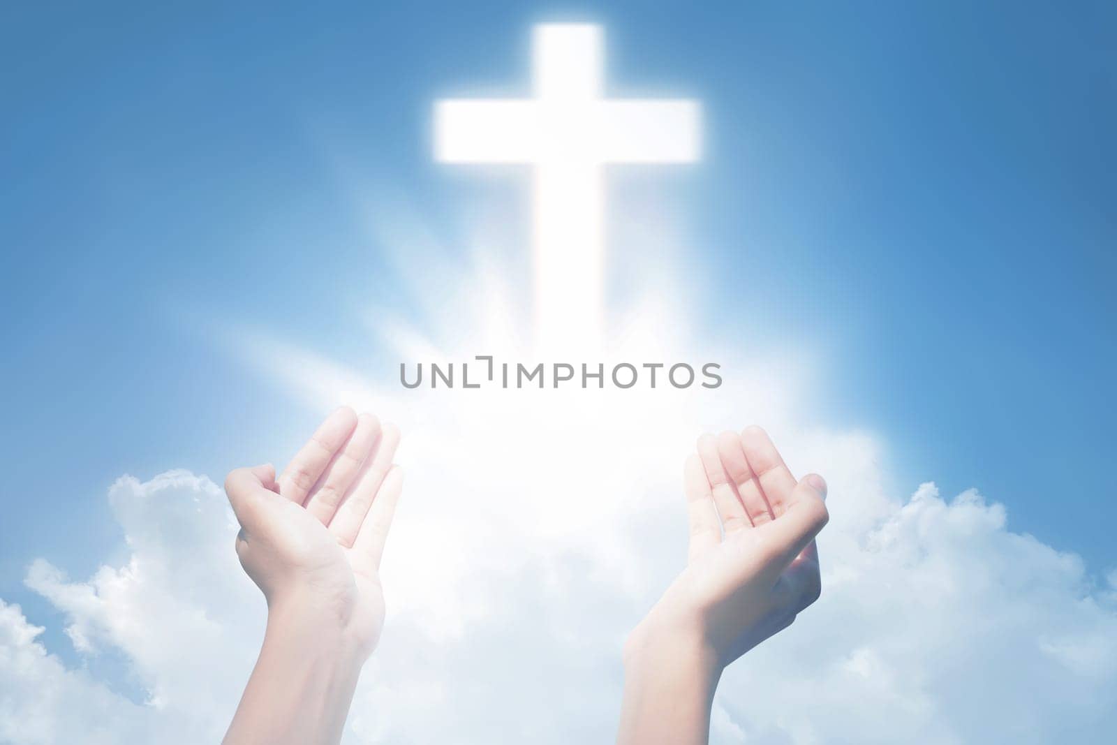 Human hands open palm and praying with cross on the sky background