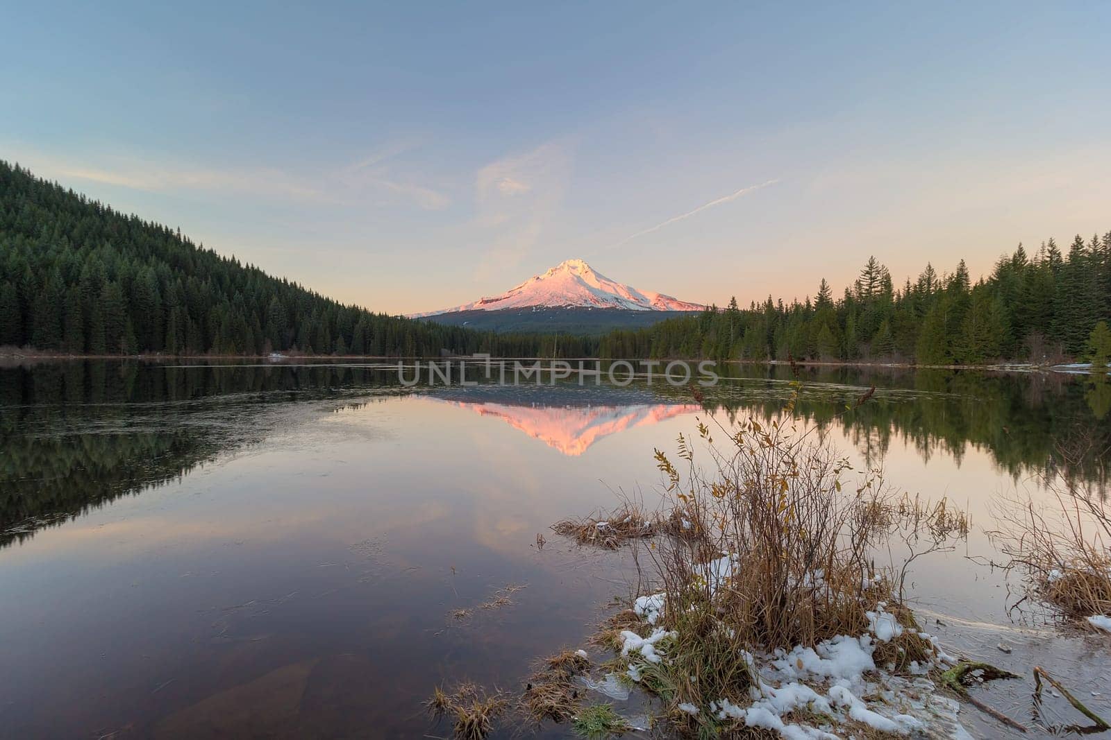 Alpenglow sunset over Mount Hood at Frozen Trillium Lake in Winter