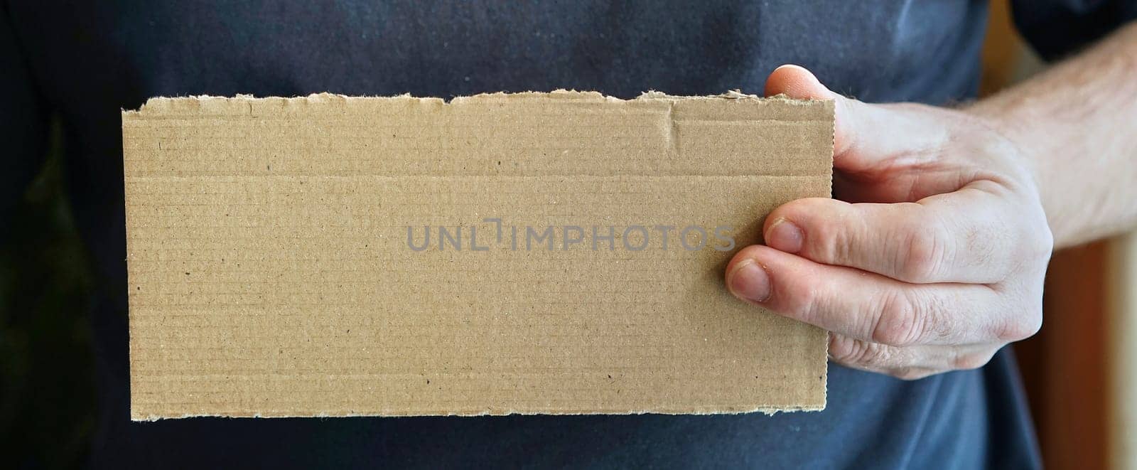 empty cardboard sign in a person's hand