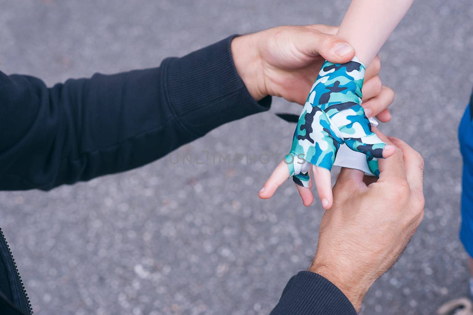 A young coach tying boxing bandages to a child's pupil. children's boxing. Blurred background. horizontal.