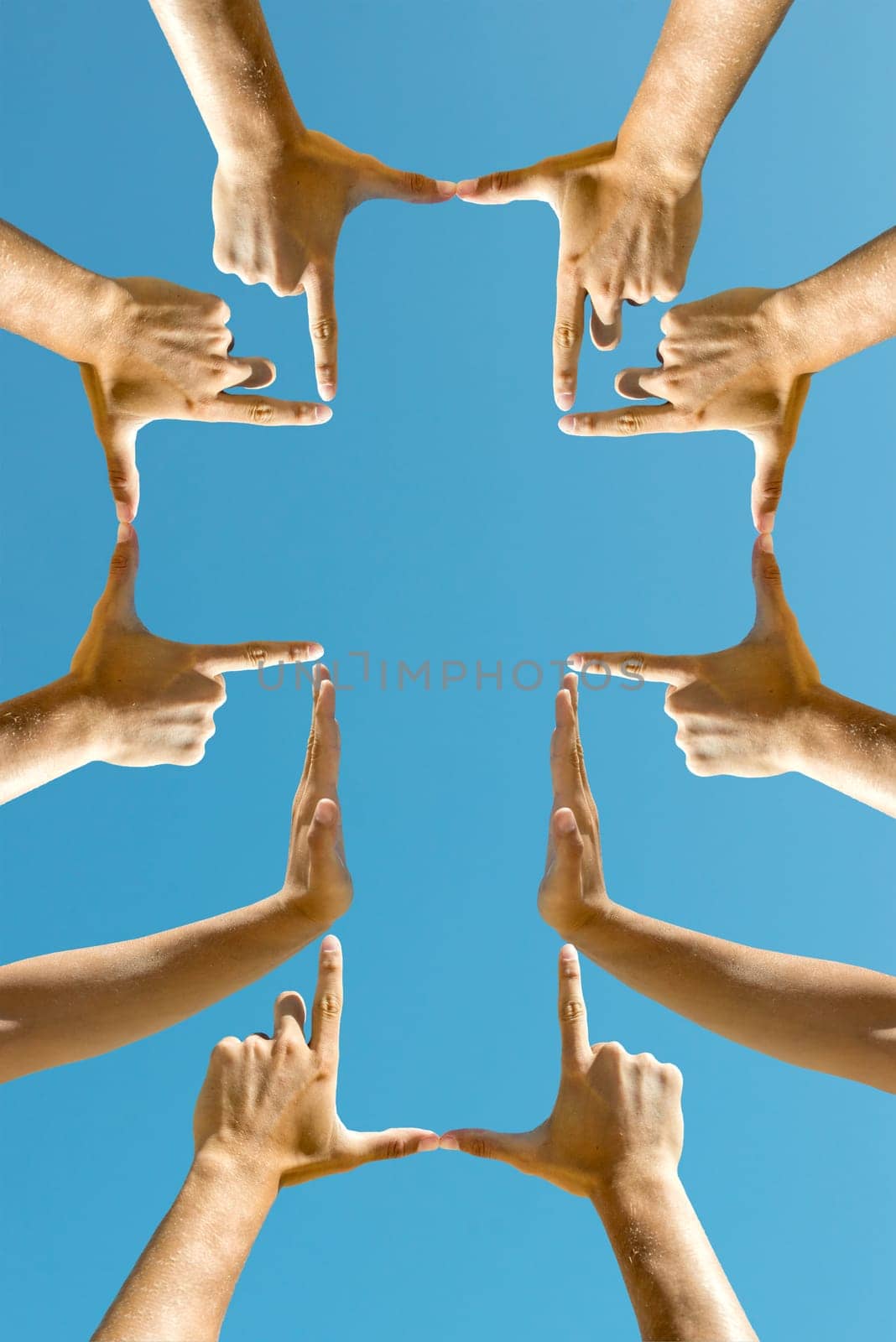 Hands forming a cross against the blue sky