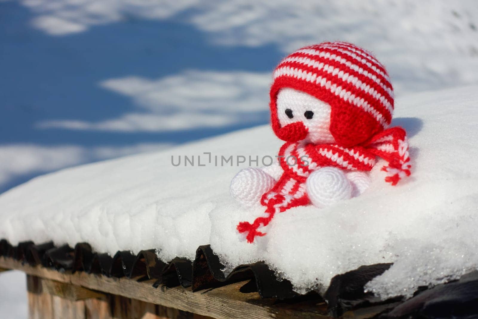 Self-crocheted snowman sits in the snow