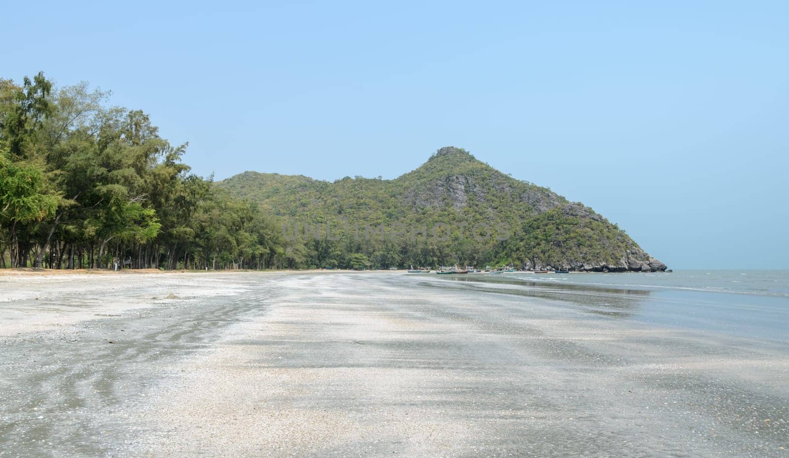 Landscape of beach with rocky mountain at low tide