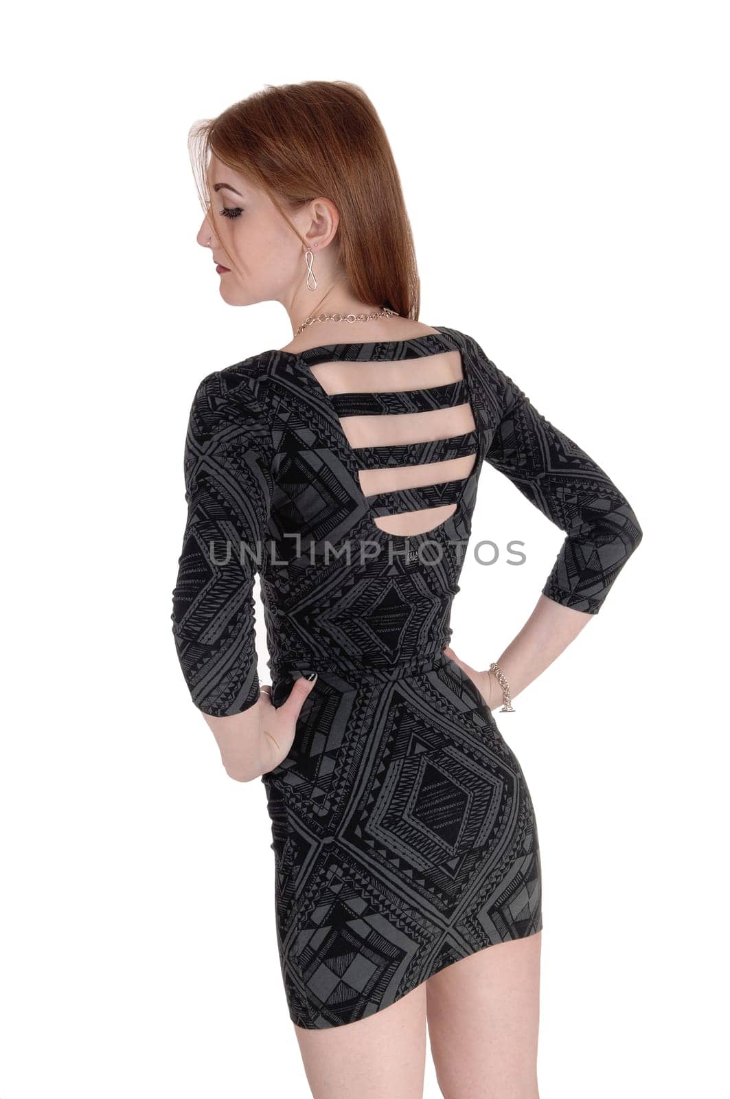 A young beautiful woman in a gray short dress standing from the back.looking down with nice jewellery, isolated for white background.