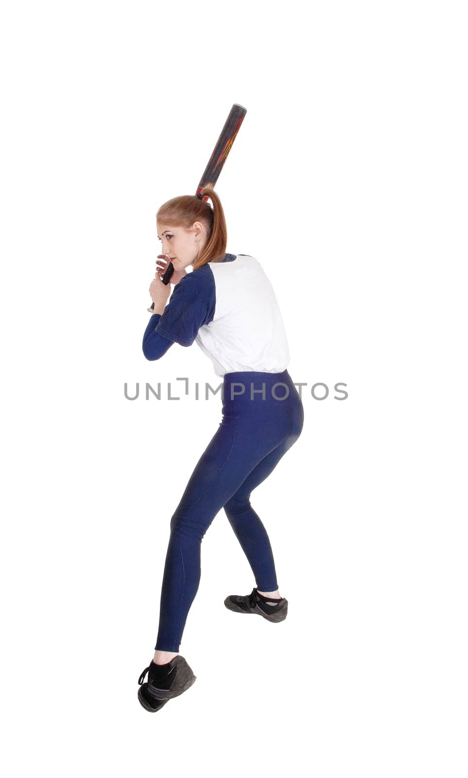 A young slim woman playing softball, swinging her bad to hit the ball.in a blue uniform, isolated for white background.