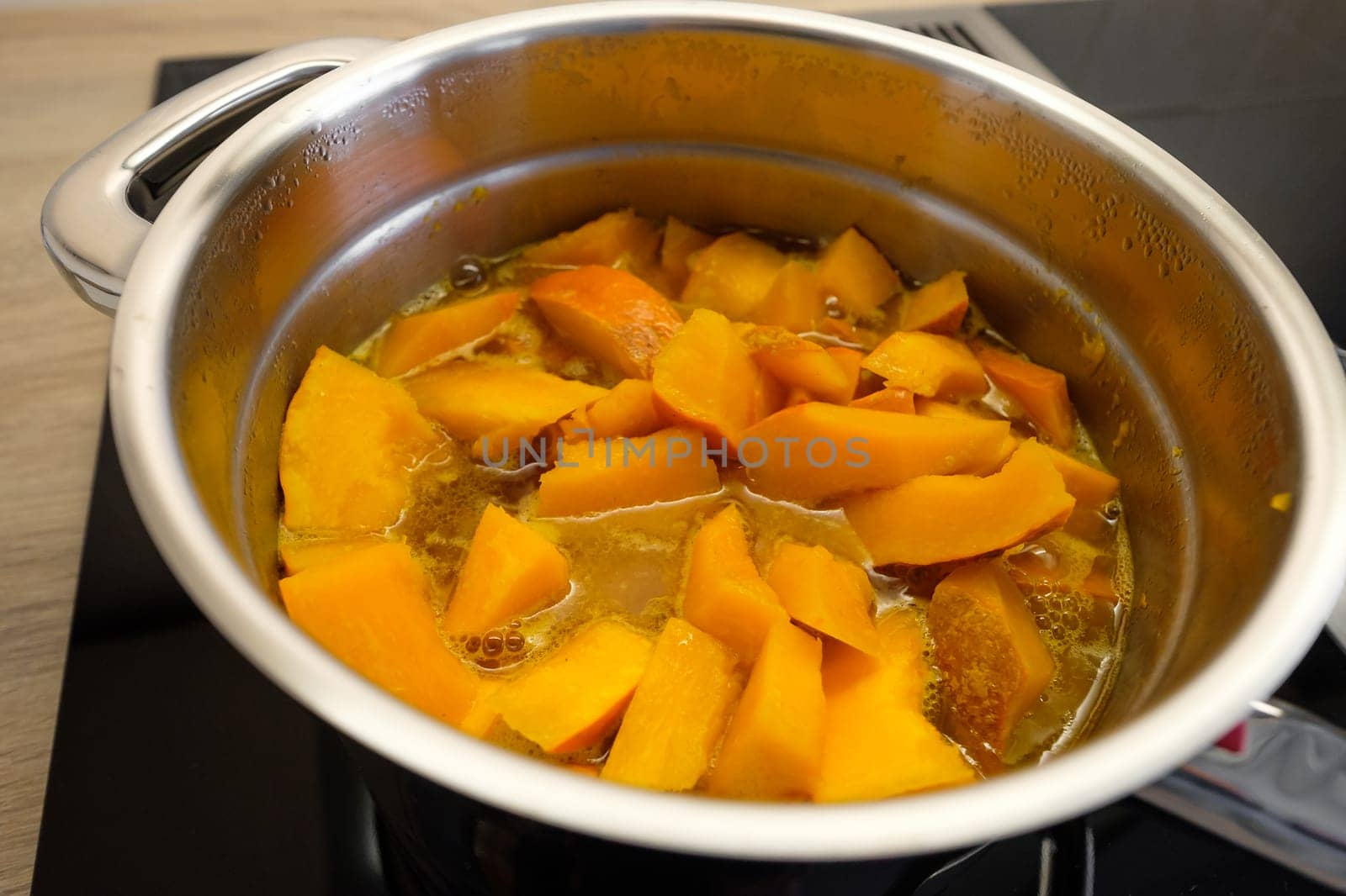Cooking orange pumpkin in a saucepan