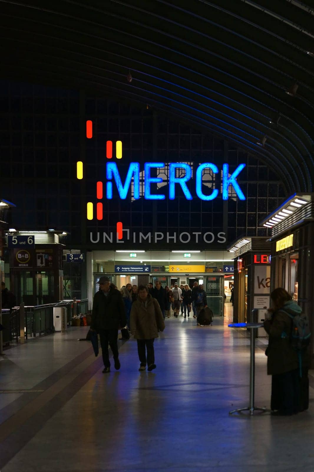 Darmstadt,Germany - October 31,2017: The interior shot of Darmstadt Central Station in the evening with travelers on the train tracks and advertising on October 31,2017 in Darmstadt.
