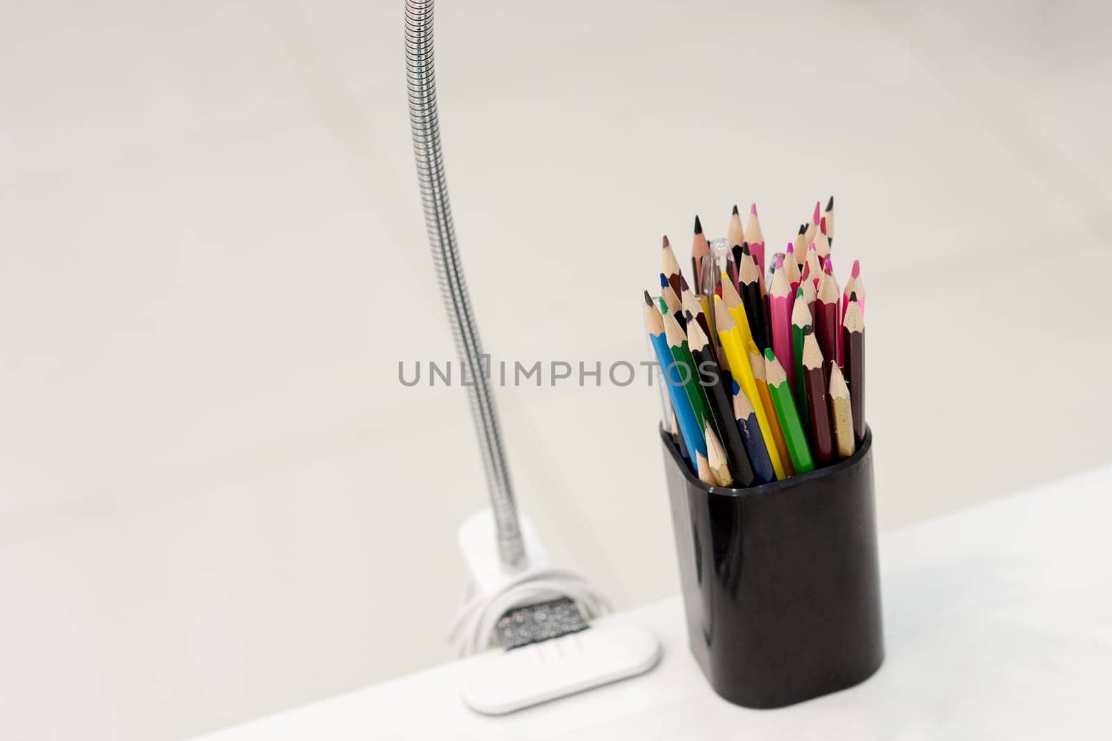 Many crayons with different colors. Back to school. Colored pencils in an glass.
