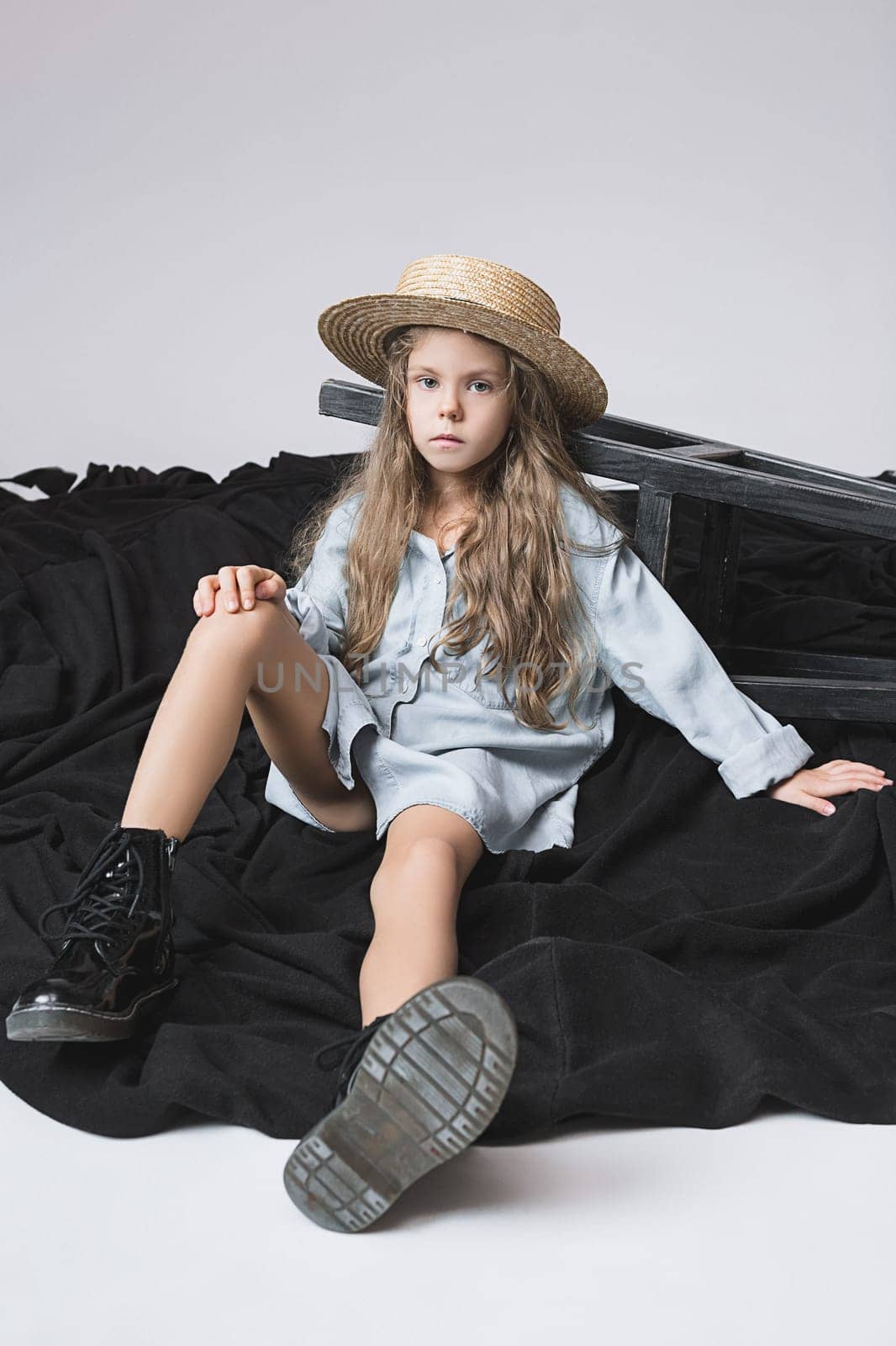 Stylish young teen girl posing at studio over gray background