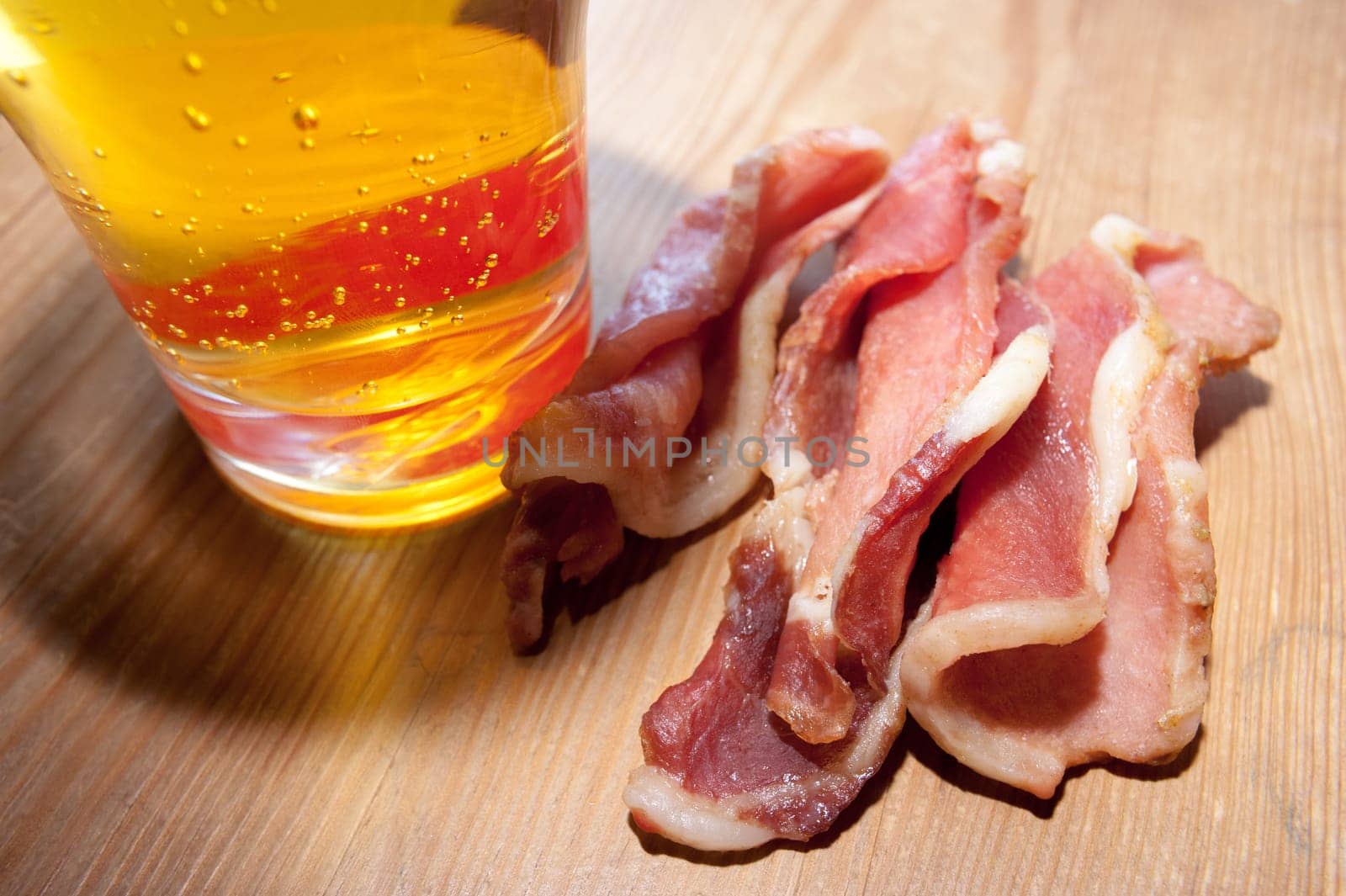 Board with home beef jerky - dried spicy meat, a large glass of beer.