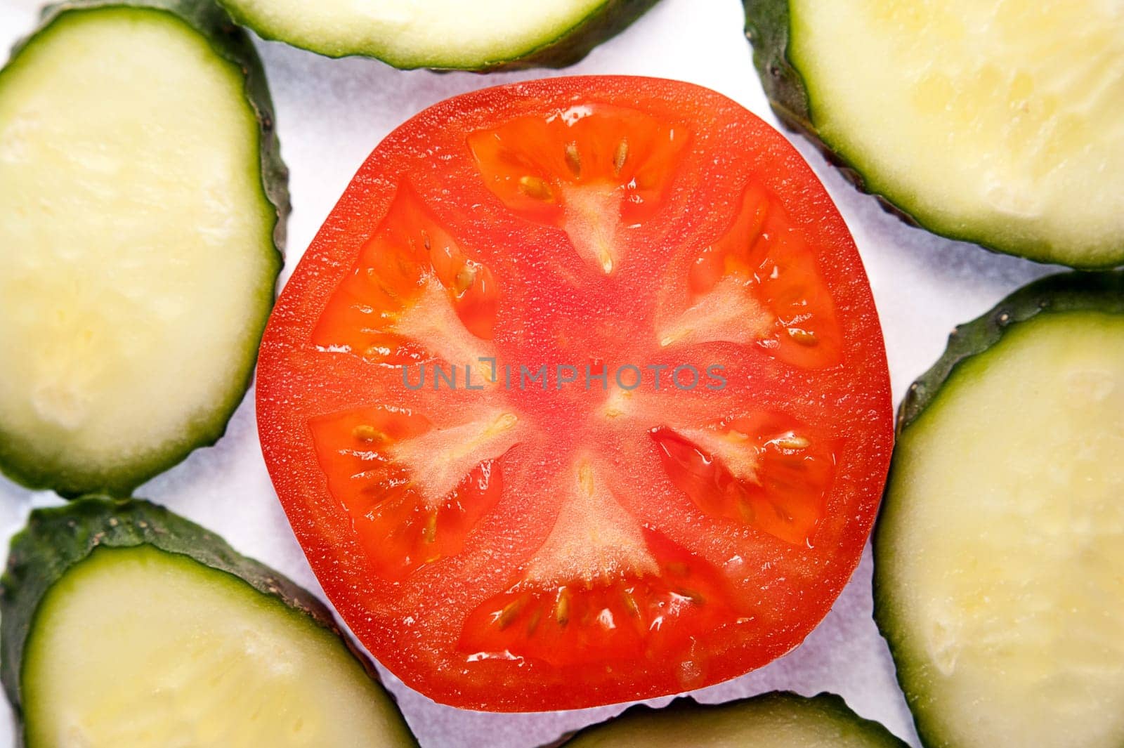 image of tomato slices and cucumber in a section. Natural background with slices of tomato. close-up, macro.