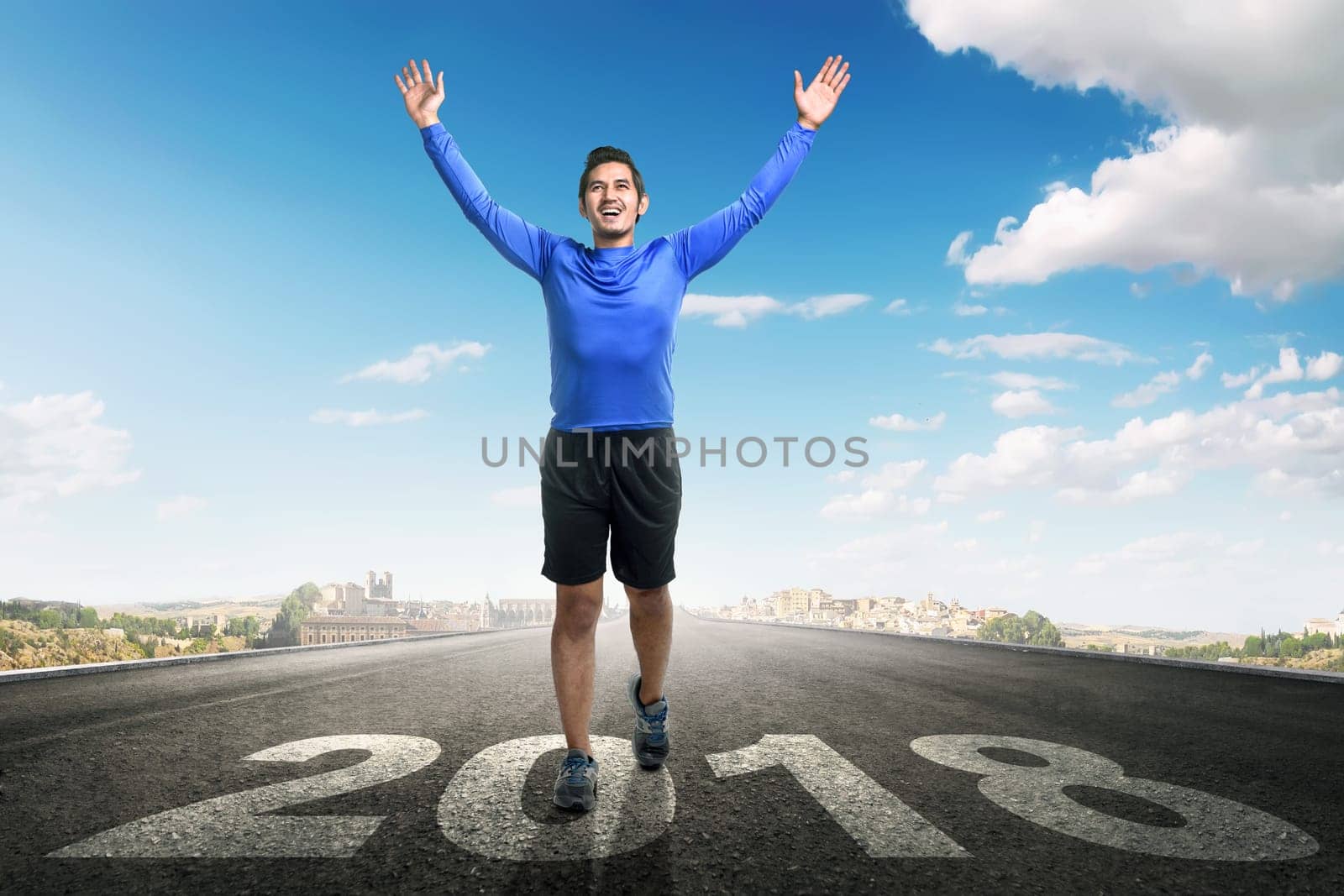 Young asian man running with 2018 number on asphalt road. Happy New Year 2018