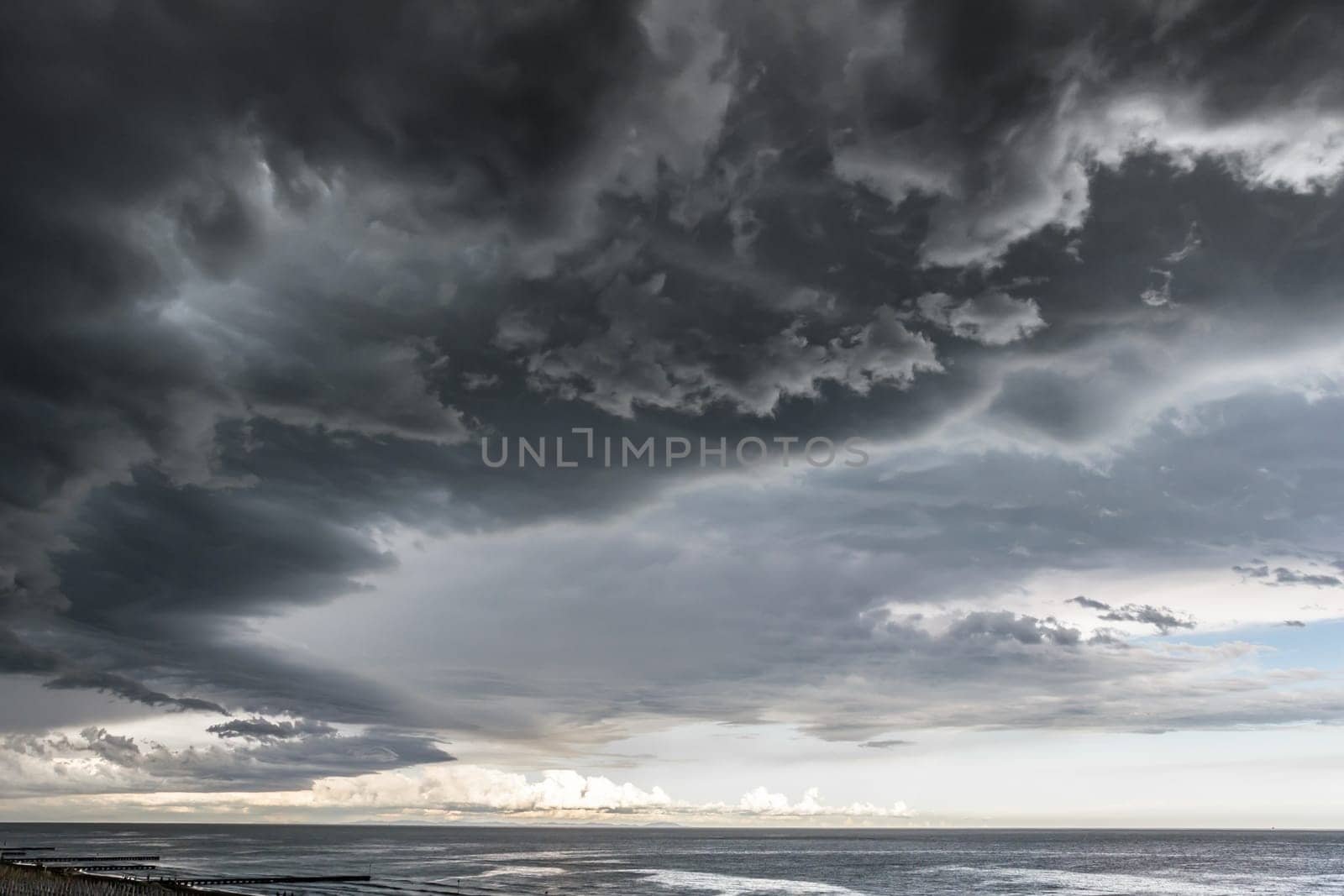 Landscape photo of a beach and dramatic thunderstorm clouds over the sea or the ocean