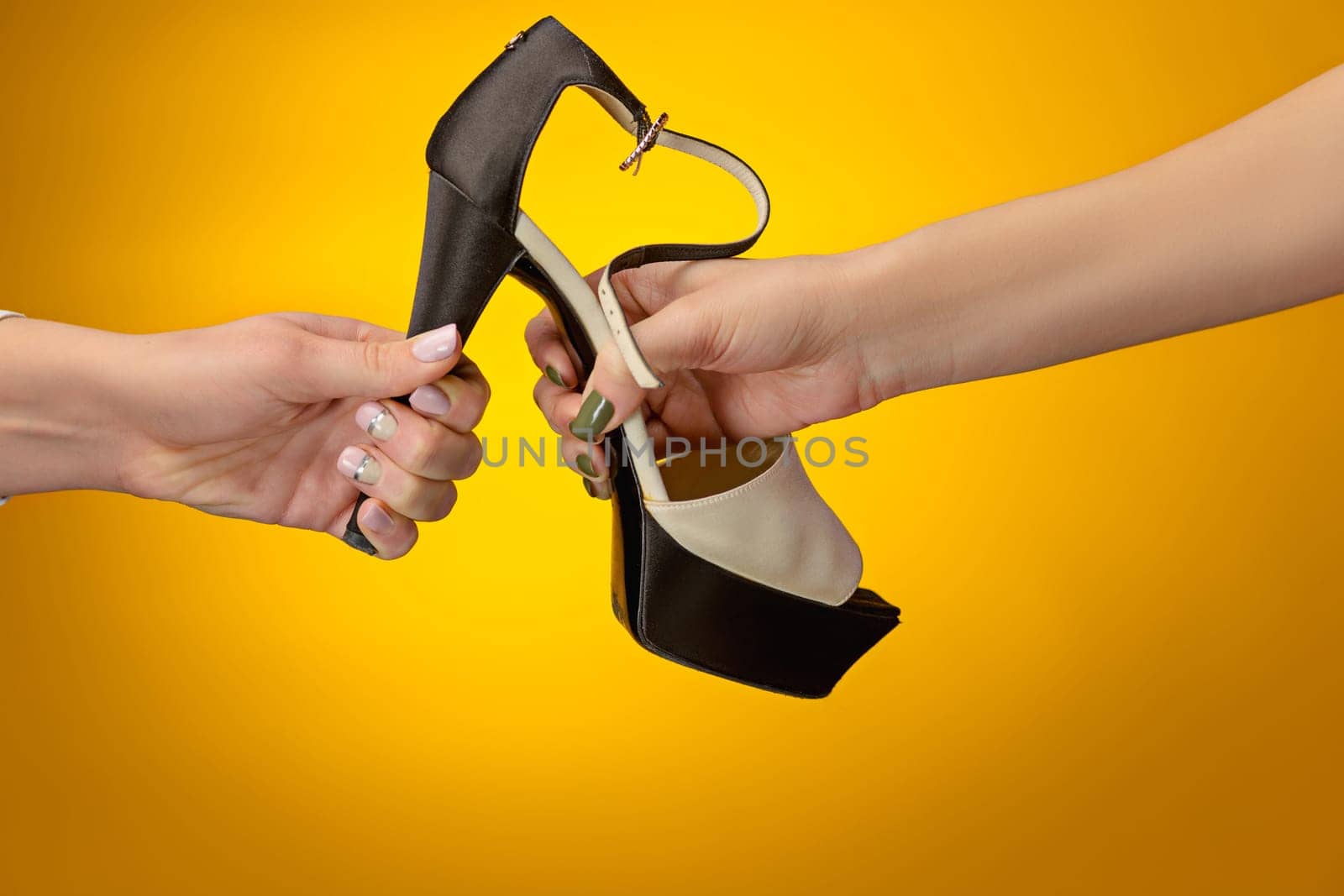 The female shoe with female and male on hands on yellow paper. Shopping and black friday concept