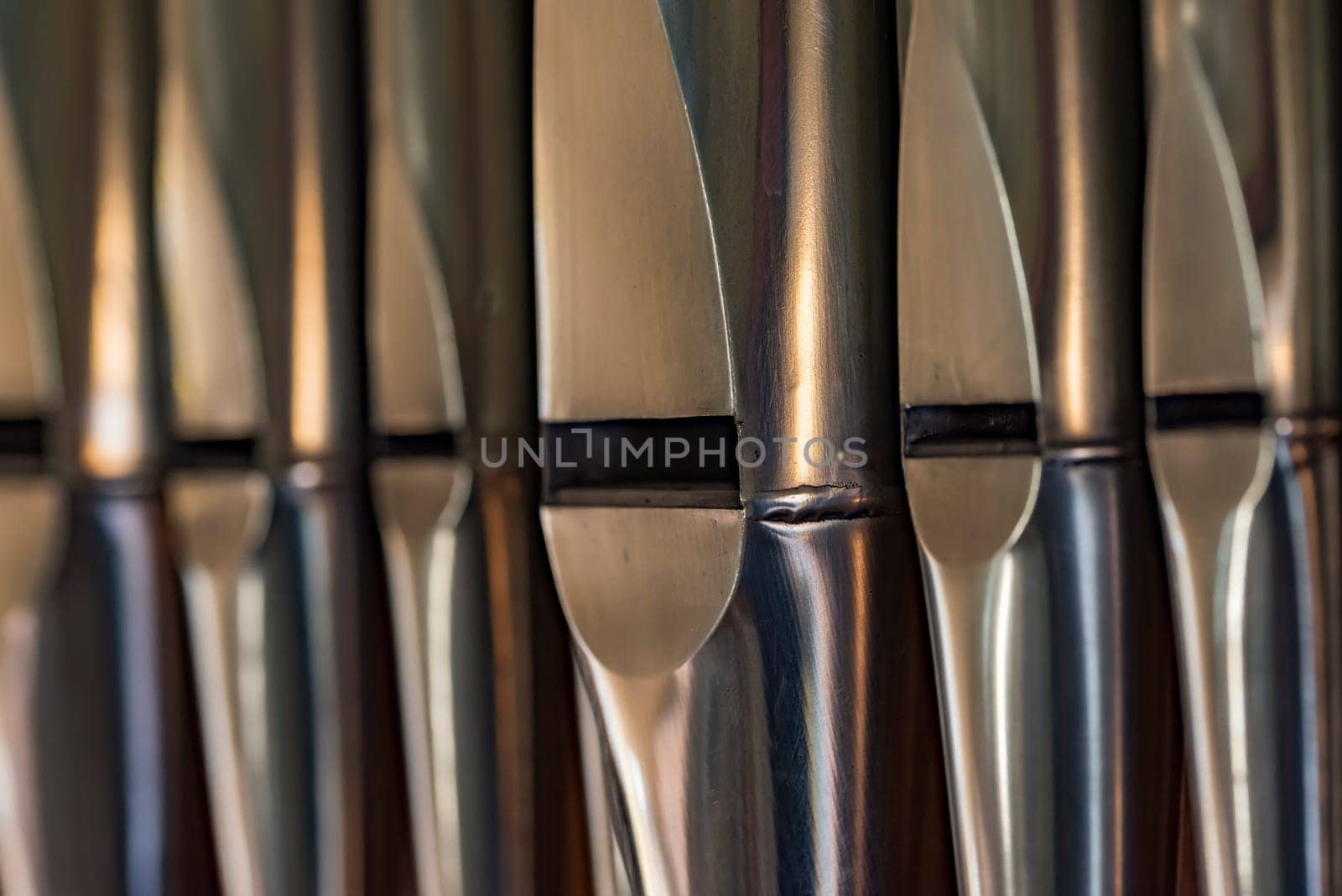Close-up of organ pipes made of lead sheet metal standing in a row in a church