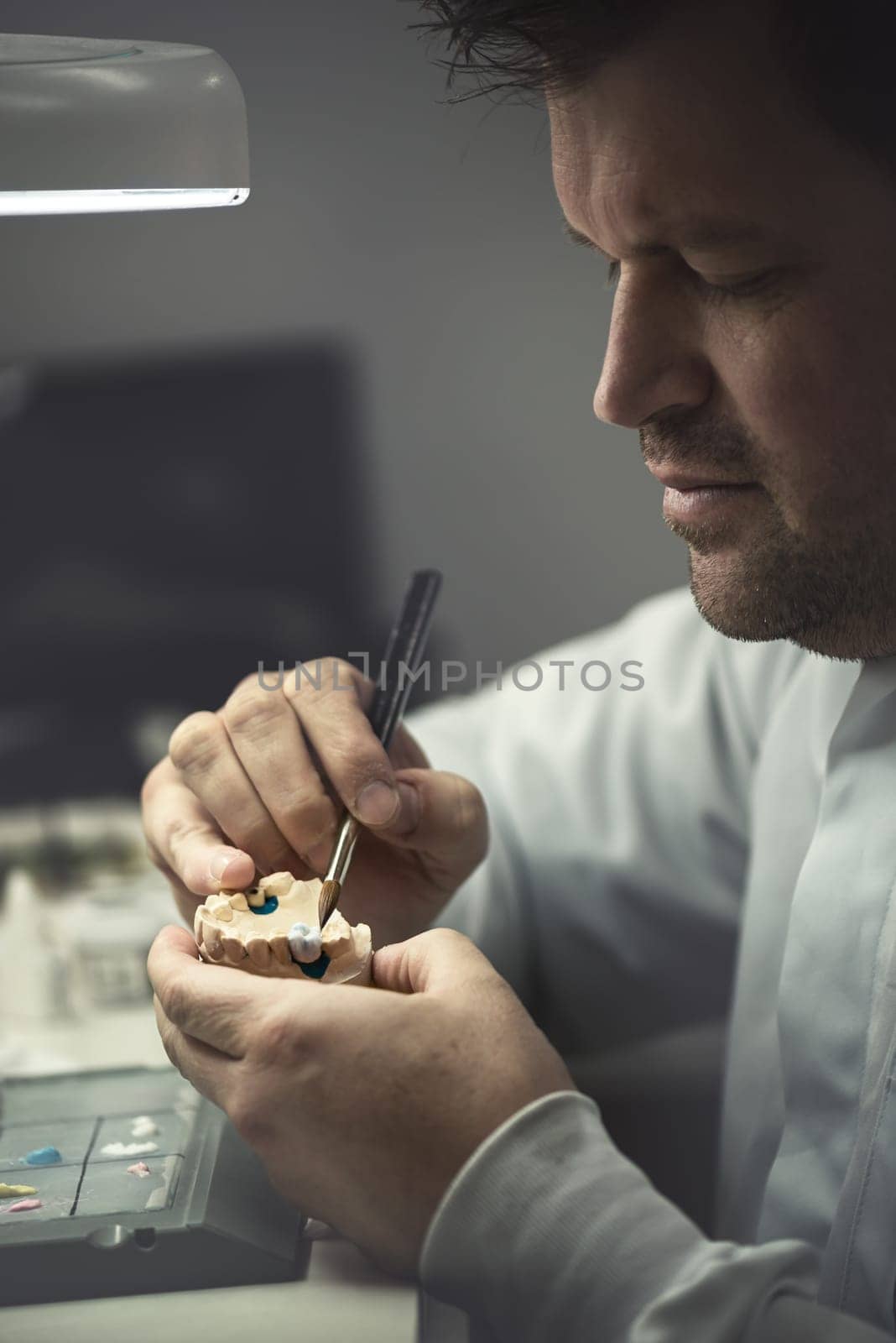 Dental prosthesis, artificial tooth, prosthetic, hands working on the denture, false teeth.