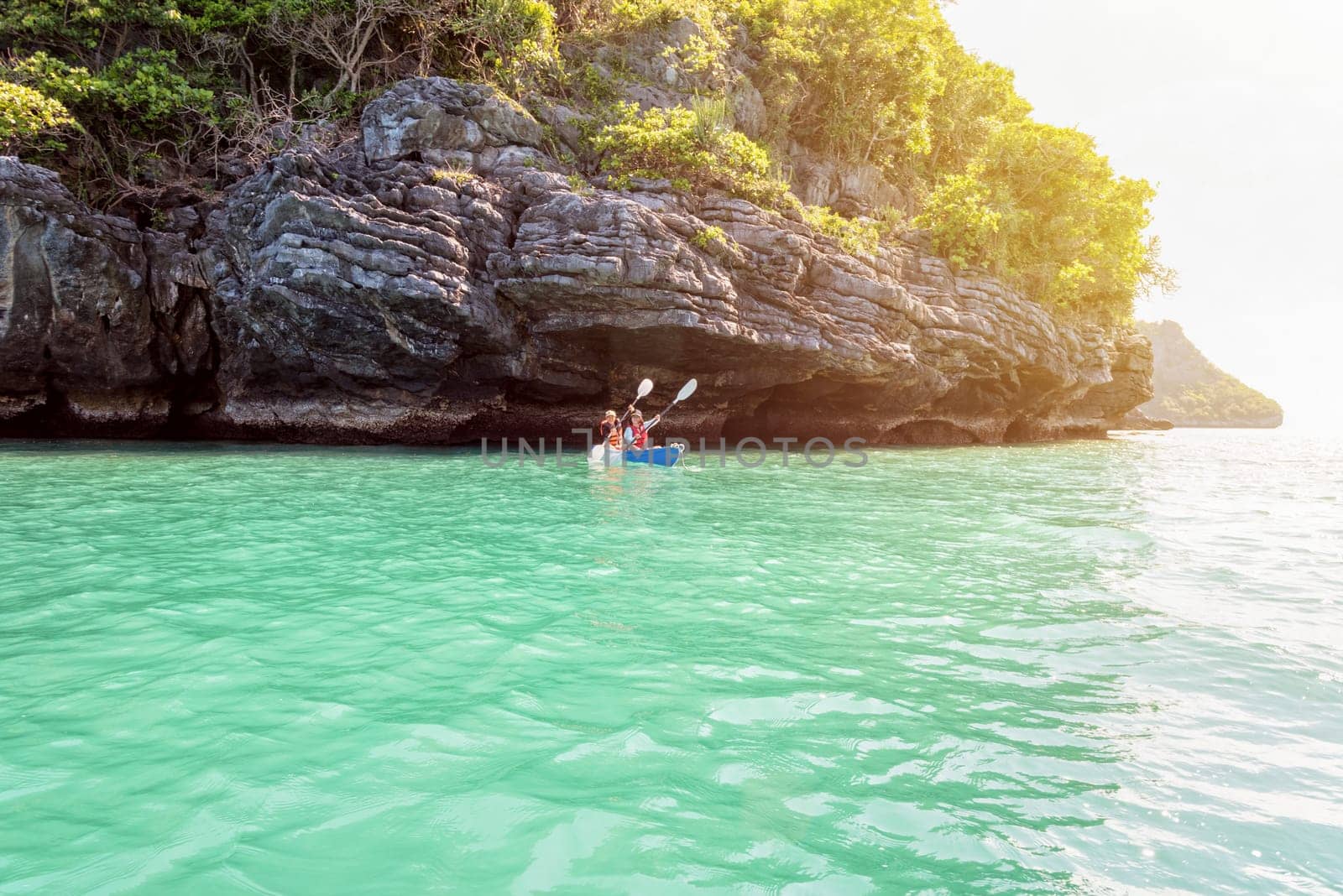 Two women are mother and daughter. Travel by boat with a kayak on the sea under sunlight at summer around Ko Phi enjoy the beautiful nature of the sea and island, Mu Ko Ang Thong National Park, Surat Thani, Thailand