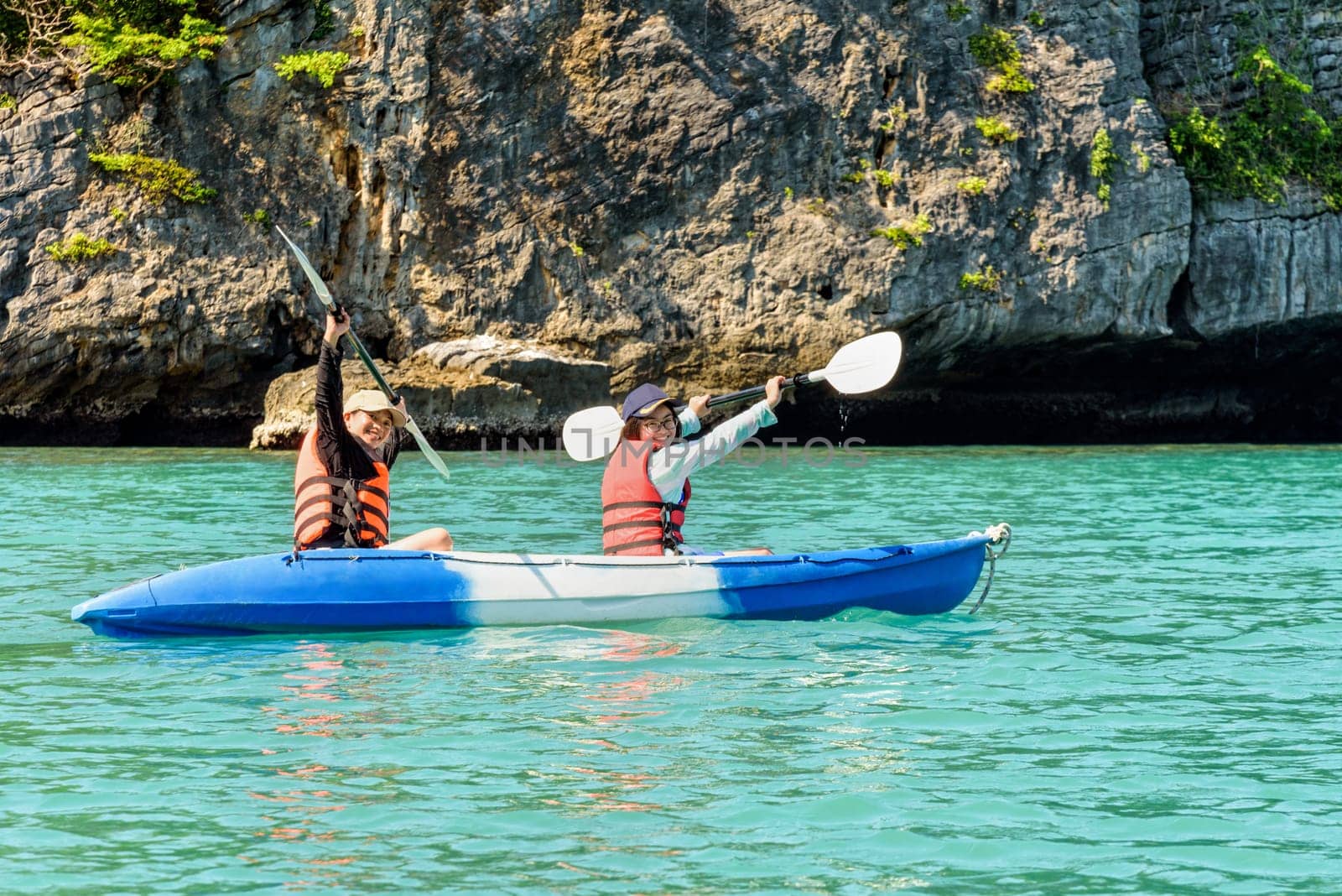 Two women are mother and daughter. Travel by boat with a kayak happy on the sea under the bright summer sky front of Ko Wua Ta lap islands at Mu Ko Ang Thong National Park, Surat Thani, Thailand