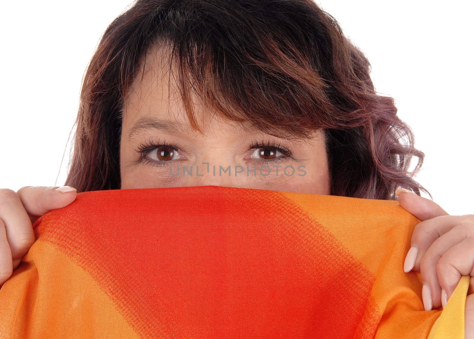 A brunette woman holding a colorful scarf over her mouths, looking.into the camera, isolated for white background.