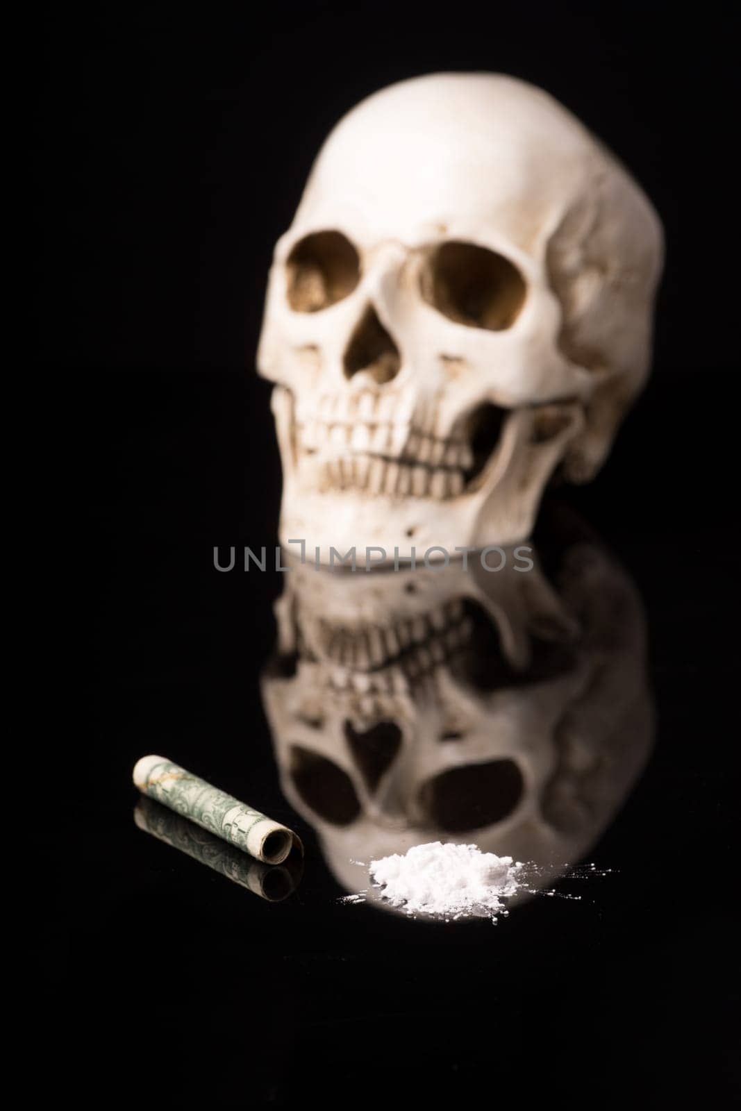 cocaine or other illegal drugs that are sniffed by means of a tube and Skull, isolated on black glossy background