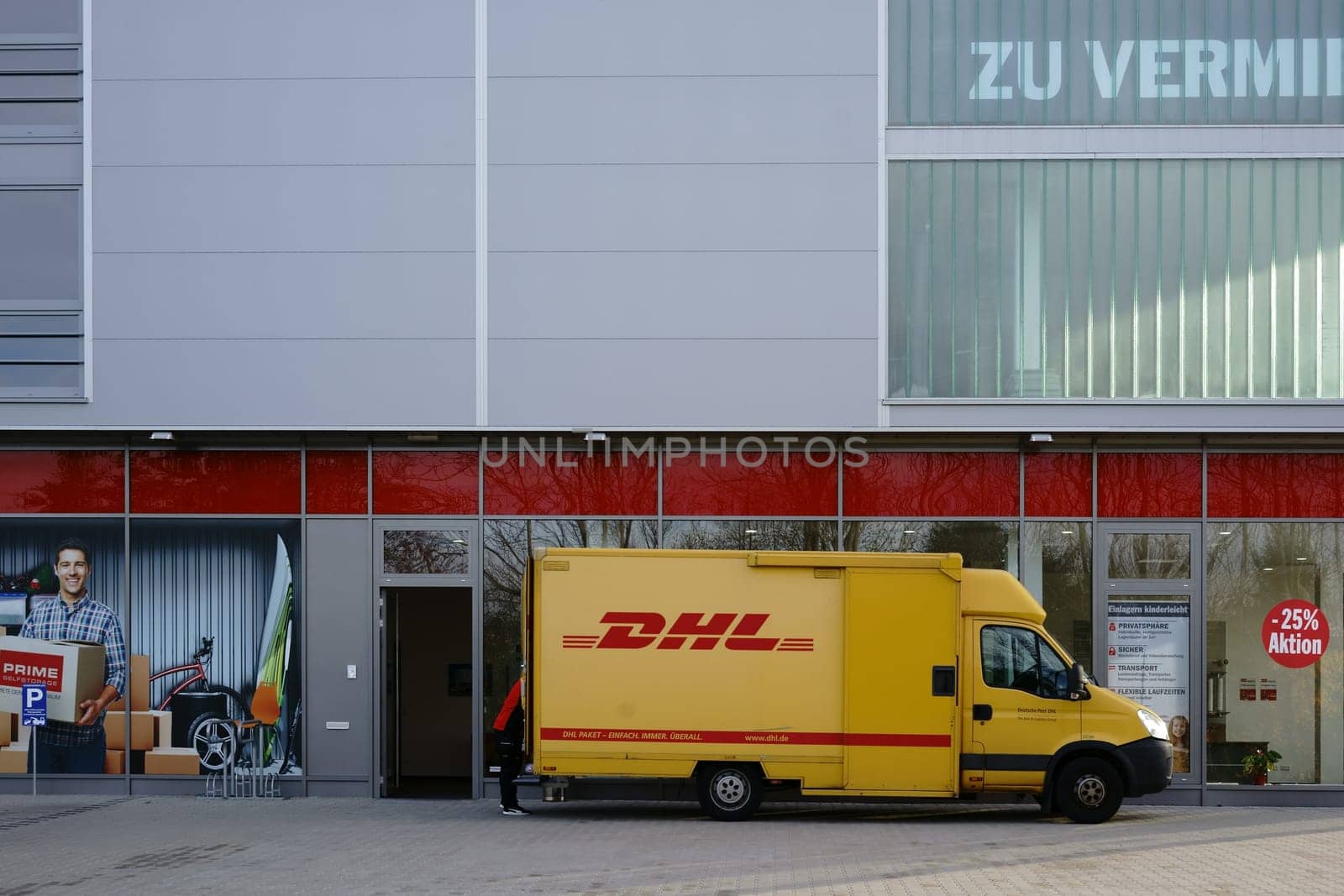 Mainz,Germany - November 14,2017: A parcel deliverer and delivery vehicle from DHL deliver parcels on November 4,2017 in Mainz.