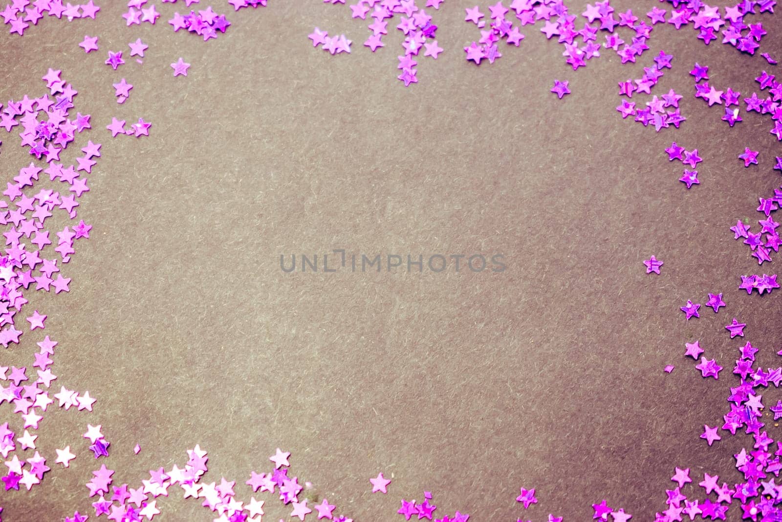 Purple glitter stars on a black background with copy space