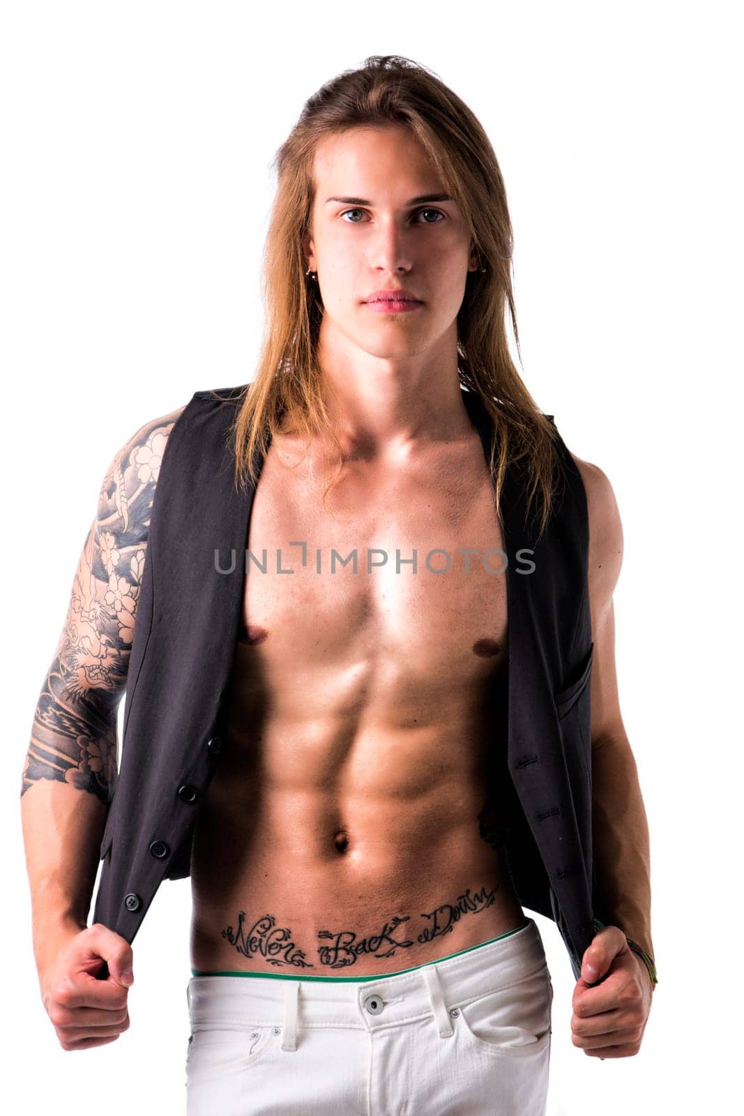 Beautiful young long haired man in jacket on naked torso, serious, posing isolated on white
