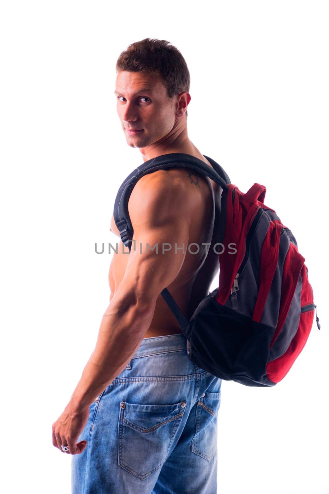 Shirtless muscular young man with rucksack on his back looking at camera, isolated