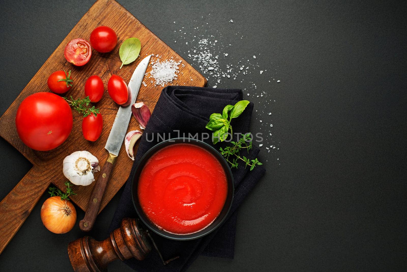 Fresh ingredients for cooking tomato sauce or soup on black background place for text. Vegan food vegetarian and healthy cooking concept.