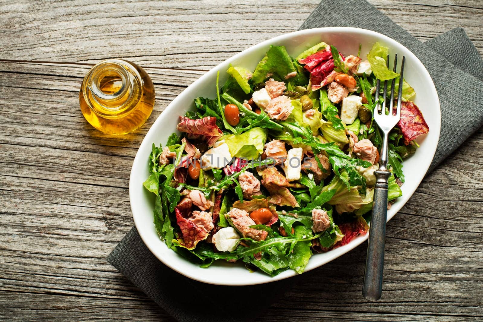 Tuna salad with lettuce beans and cheese on wooden table
