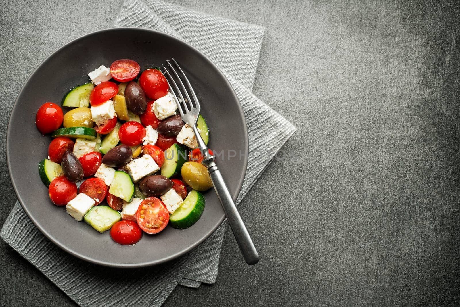 Salad with cheese and fresh vegetables on gray background. Greek salad.