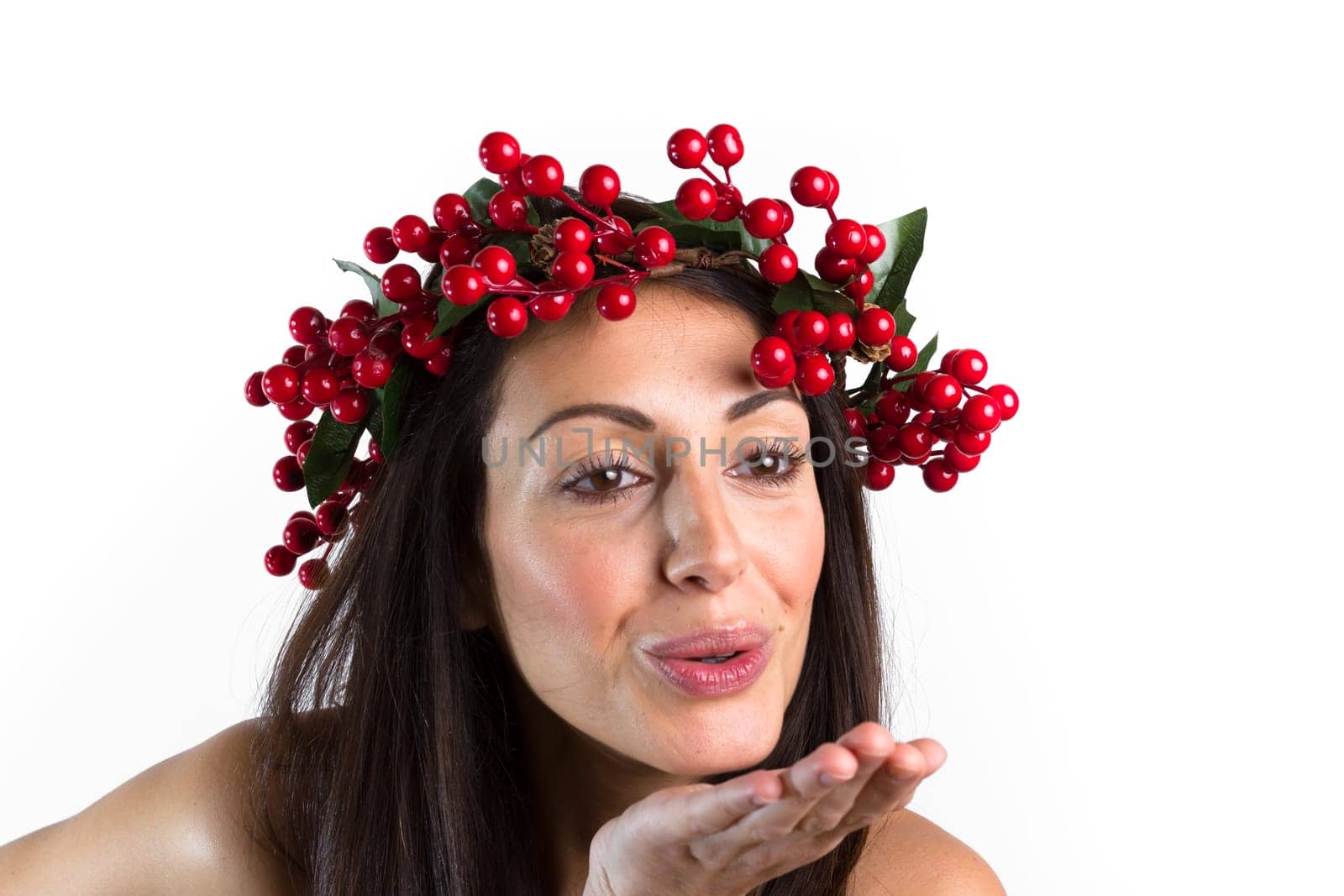 Christmas or New Year beauty woman portrait isolated on white background. Smiling young woman with wearing a Christmas wreath on her head, send a kiss. Natural makeup.