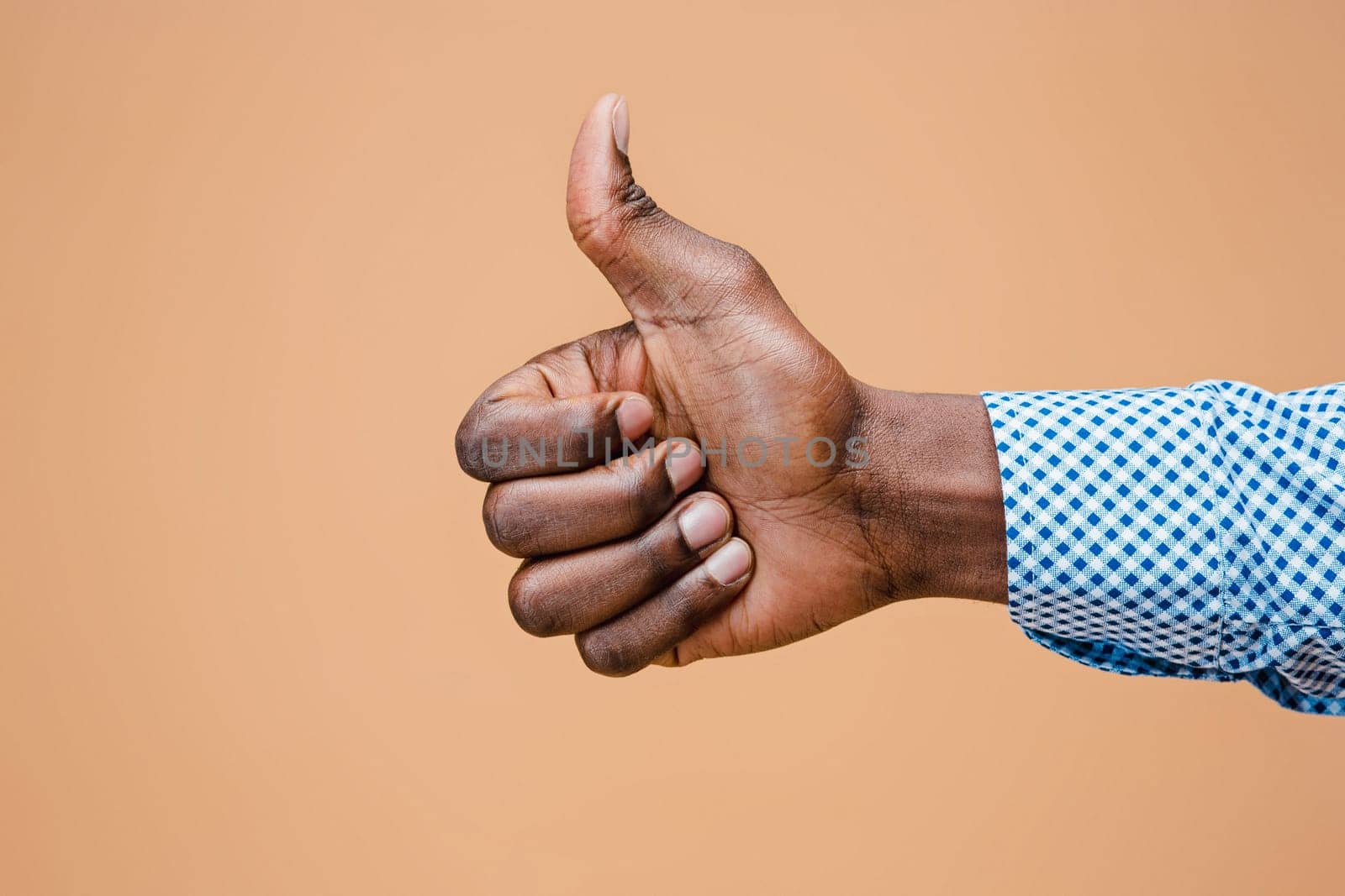 Hand showing OK sign isolated on brown background. Close-up of positive gesture, like, agreement, accept concept concept