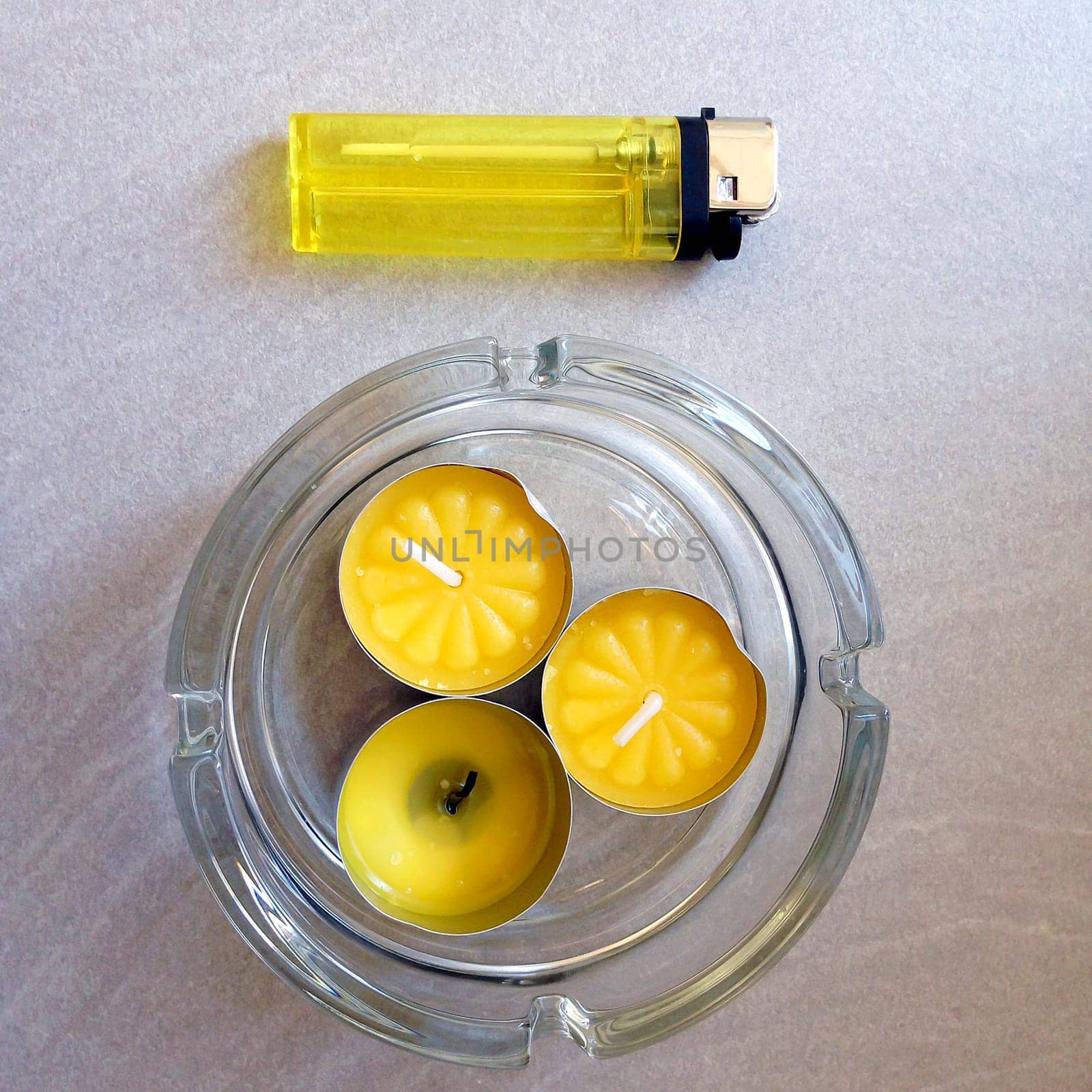 aerial view of three little yellow aromatic candles with a yellow lighter