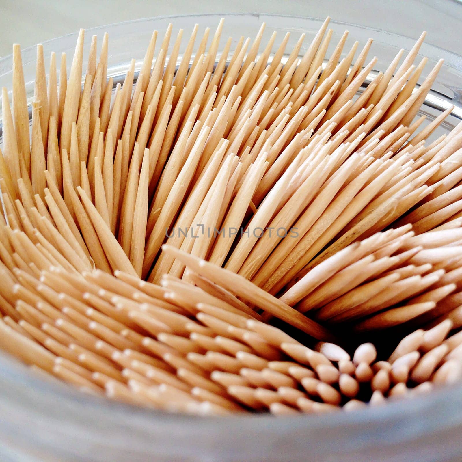 close up of a group of bamboo toohtpicks in a glass jar